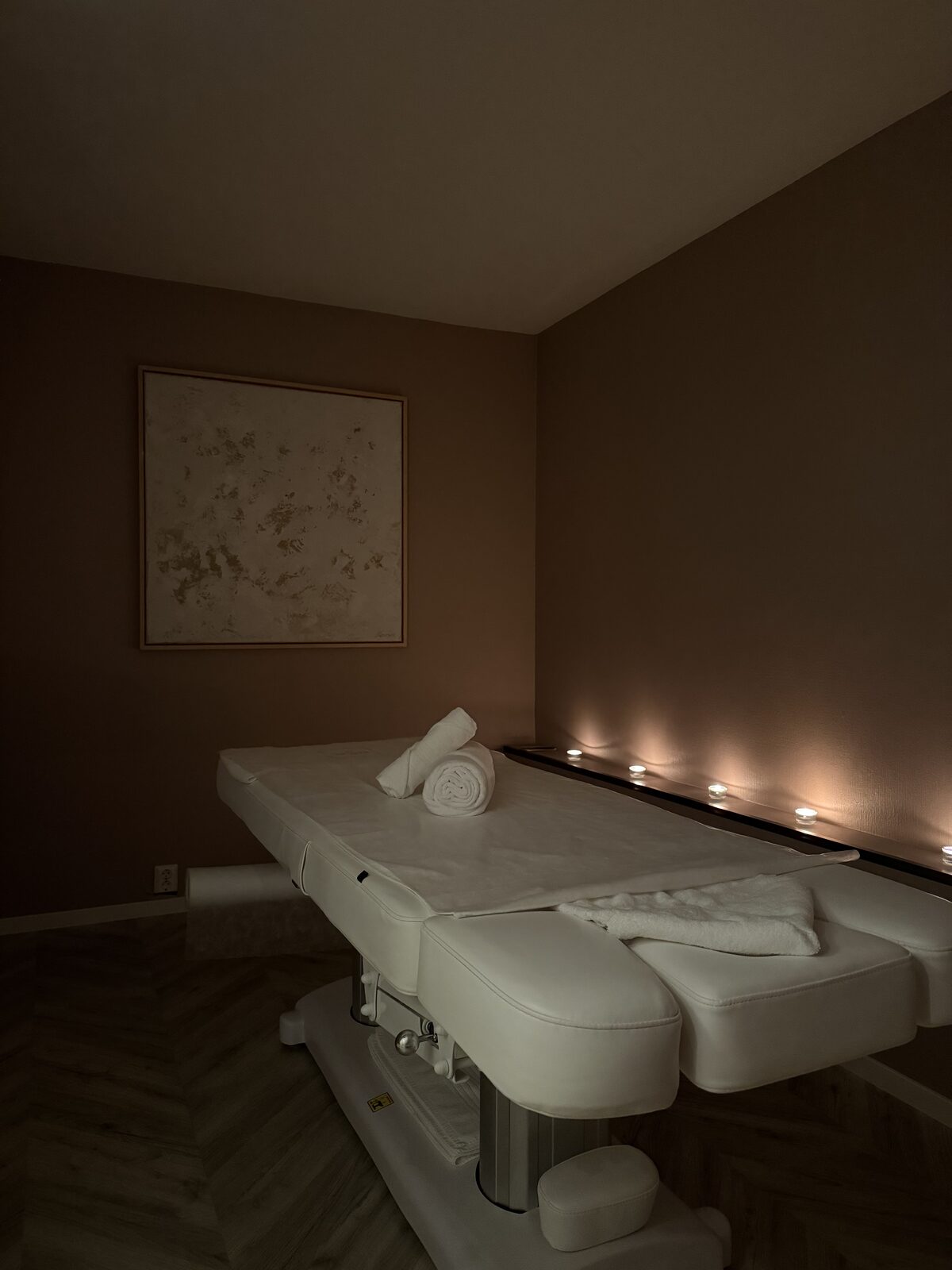 Behandlingsrom hos Ritual Spa med dempet lys og oppredd benk